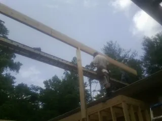 Carpenter setting a ridge beam over a new addition frame — Ice Dam Removal by Roofing Brothers in Free Union