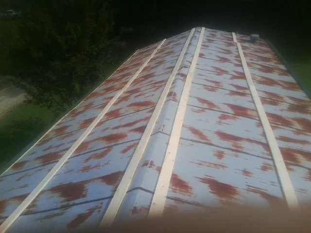 Rusted metal roof panels with new wood purlins before replacement — Storm Damage Roof Repair in Free Union by Roofing Brothers