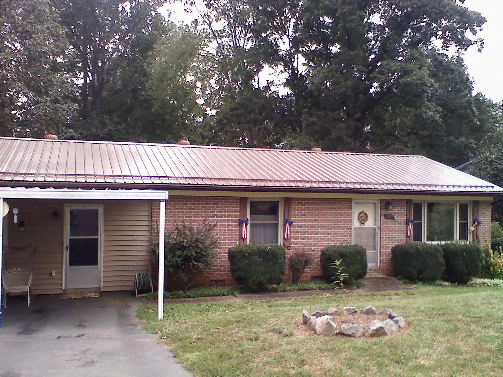 Bronze metal roof and carport on a brick ranch home — Roof Repair work by our crew in Free Union