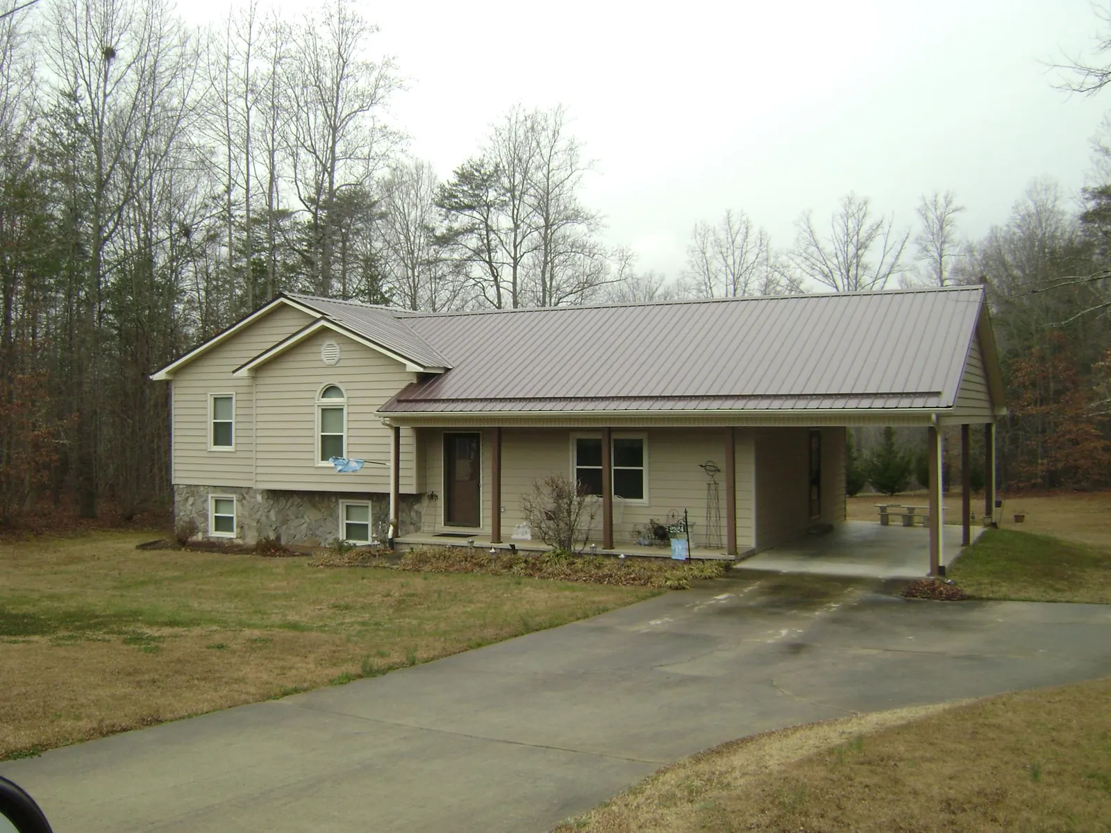 Brown metal roof on a tan split level home with an attached carport in Free Union
